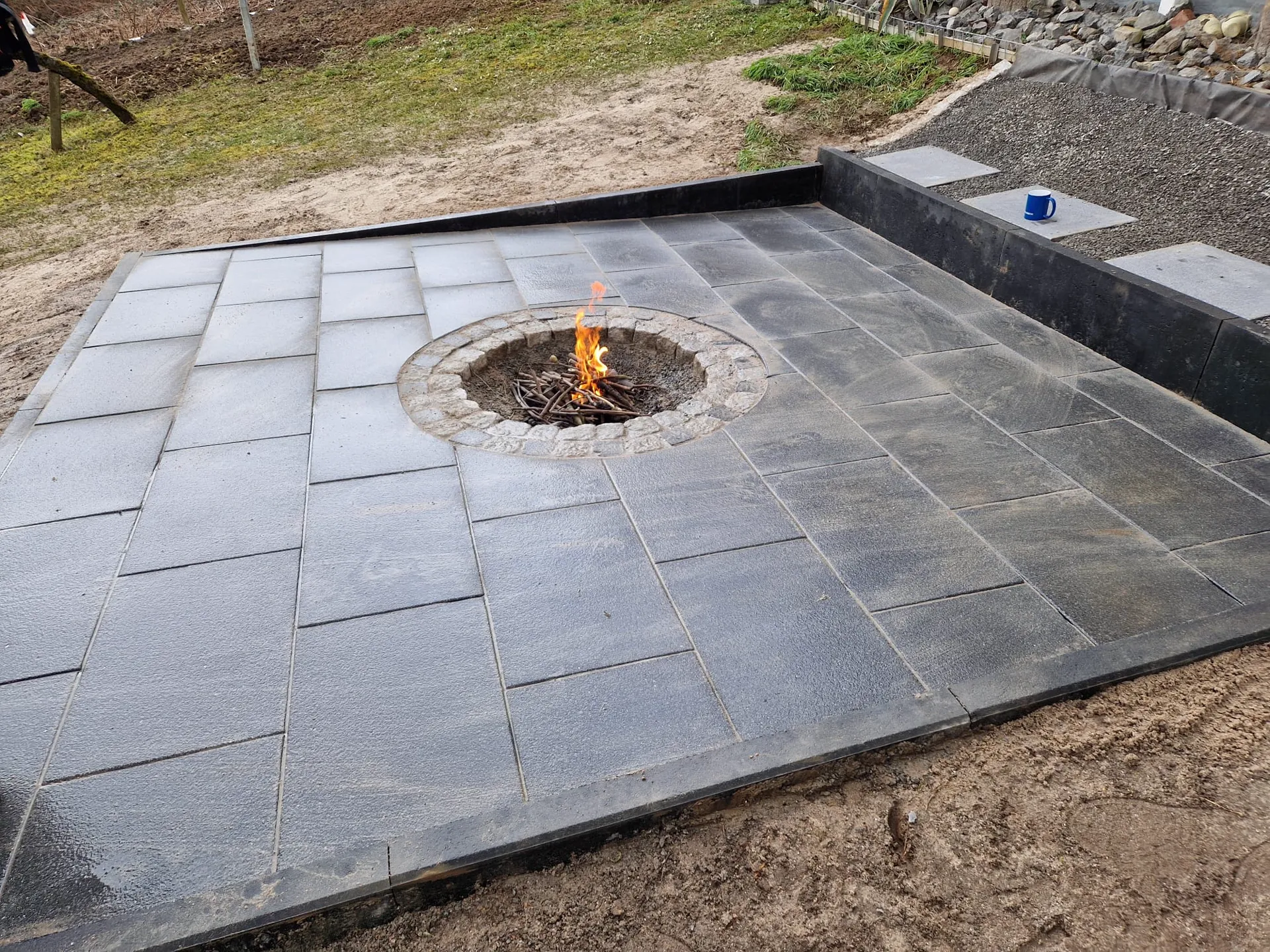 Feuerstelle mit Natursteinbank und Sitzplatz